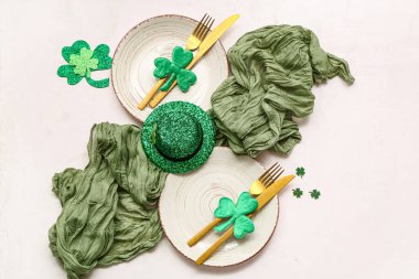 Beyaz arka planda dekoratif şapkayla Aziz Patrick Günü kutlamaları için sofra kurulumu