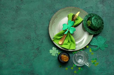 Yeşil grunge arka planda dekoratif şapka ve kazan ile Aziz Patrick Günü kutlamaları için masa.