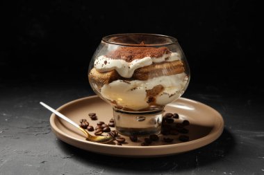 Siyah grunge arka planda lezzetli tiramisu ile cam, yakın plan