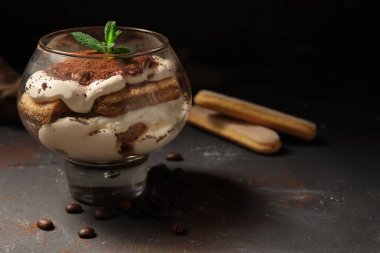 Siyah grunge arka planda tatlı tiramisu ile cam, yakın plan