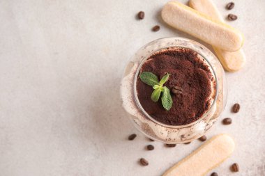 Beyaz grunge arka planda tatlı tiramisu ile cam, yakın plan