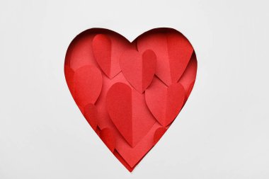 Kırmızı kağıt kalpler kesilen beyaz kağıtlardan görülebilir. Sevgililer Günü kutlaması