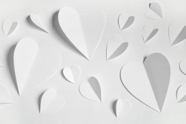 Beyaz arka planda kağıt kalpli kompozisyon, yakın plan. Sevgililer Günü kutlaması