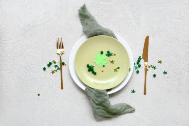 Aziz Patrick Günü kutlamaları için masa ayarlandı. Kağıt yonca ve beyaz grunge arka planda konfeti ile.