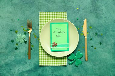 Aziz Patrick Günü kutlamaları için masa ayarlayın. Yeşil grunge arka planda tebrik kartı ve konfeti.