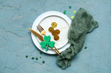 Dekoratif yonca ve mavi grunge arka planda bozuk paralarla Aziz Patrick Günü kutlamaları için masa ayarlayın.