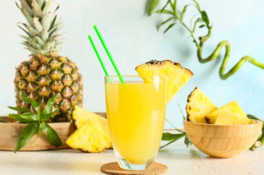 Beyaz Grunge arka planında bir bardak taze ananas suyu, yakın plan.