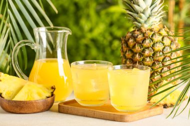 Dışarıdaki beyaz masada bir bardak lezzetli ananas suyu, yakın plan.