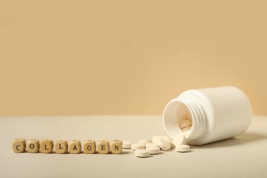 Bej arka planda kolajen hapları olan hap kutusu, yakın plan.