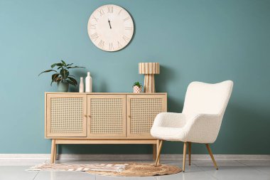 Büyük saati, klozeti ve koltuğu olan şık bir oda.