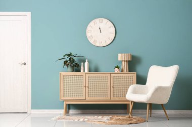 Büyük saati, klozeti ve koltuğu olan şık bir oda.