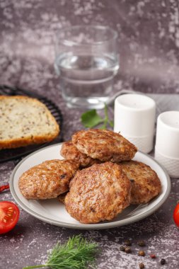 Mutfaktaki grunge masasında pirzola, domates ve biber tabağı.