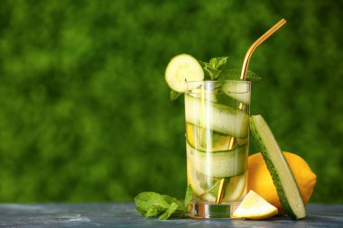 Bir bardak salatalıklı limonata ve açık hava masasında nane şekeri.