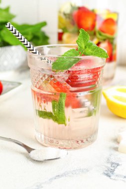 Beyaz masada çilekli bir sürahi taze limonata.