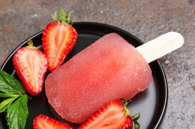 Siyah tabak çilekli dondurma, taze böğürtlen ve nane yapraklı koyu grunge arkaplan