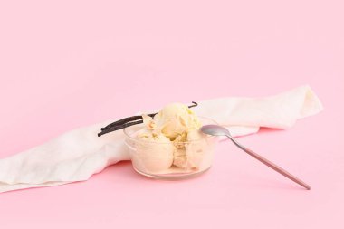 Pembe arka planda bir top vanilyalı dondurma.