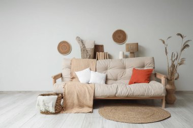 Konforlu kanepe, otlar ve salonun içinde ekoseli hasır sepet.