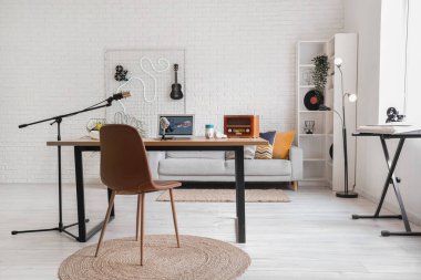 Podcaster 'ın çalışma yeri, kanepesi ve raf ünitesi olan stüdyosunun içi.