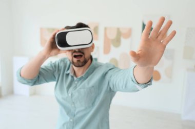 Modern sanat galerisinde VR gözlük kullanan genç adam, yakın plan.