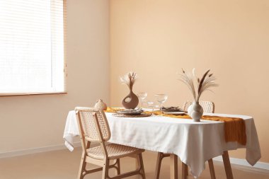 Yemek odasında pampalar ve bardaklar olan zarif bir masa.