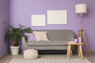 Rahat kanepe, sehpa, resimler ve lamba oturma odasının içinde.