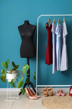 Manken, ayakkabı ve elbise askısı olan soyunma odasının içinde.