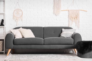 Oturma odasının içi siyah kanepe ve minderlerle dolu. Yin Yang konsepti