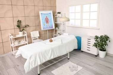 Masaj terapistinin bürosunun içinde kanepe, raf üniteleri ve modern tıp merkezindeki tabelalar.