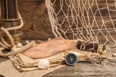 Modern pusula, eski kitap, dürbün, dünya haritası ve ahşap zemin üzerine ağ.