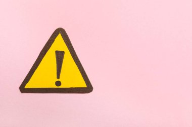 Pembe arka planda ünlem işareti olan sarı üçgen