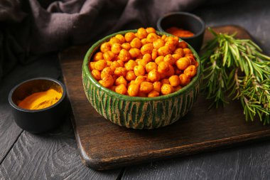 Lezzetli kızarmış nohut, biberiye ve siyah ahşap kaplama baharatlı kase.