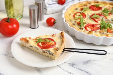 Beyaz arka planda roka yapraklı domatesli tart.