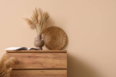 Bej duvarın yanında kitap ve otlarla dolu tahta çekmeceler, yakın plan.