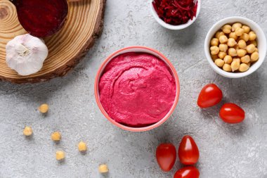 Bir kase lezzetli pancar humusu, domates, bezelye ve sarımsak.