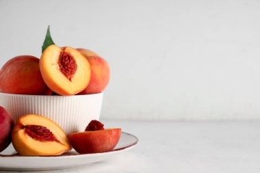 Beyaz arka planda olgun şeftalili tabak ve tabak.