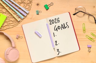 2026 gollü defter, ahşap arka planda kırtasiye ve gözlük