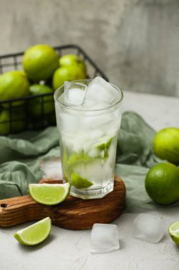 Beyaz masanın üzerine bir bardak kireç dökülmüş su. Gri arka plan, yakın plan.