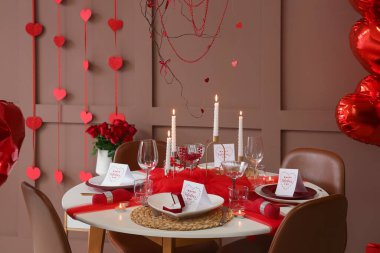 Kutlama masası, yanan mumlar, tebrik kartları ve nişan yüzükleri yemek odasında. Sevgililer Günü kutlaması