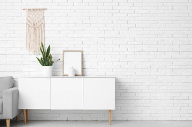 Oturma odasında çerçeveli ve çiçekli çekmeceler.