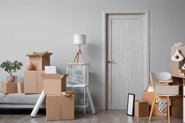 Taşındığı gün odada karton kutular olan kanepe ve işyeri