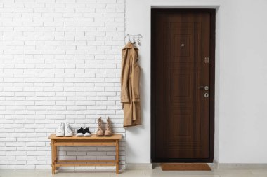 Koridorun içinde askılık, kapı ve ayakkabı standı var.