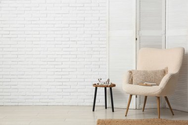 Katlanır ekran, koltuk ve masa ile oturma odasının içi