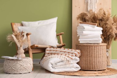 Koltuğu, sepeti ve çarşafı olan bir oda.