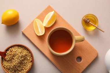 Limonlu sıcak karabuğday çayı ve gri arka planda bir kase bal.