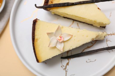 Bej arka planda tatlı vanilyalı cheesecake tabağı, yakın plan.