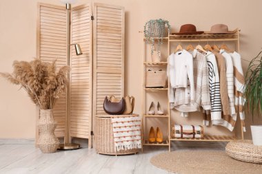 Giysi askısı ve katlama perdesi olan soyunma odasının içinde.