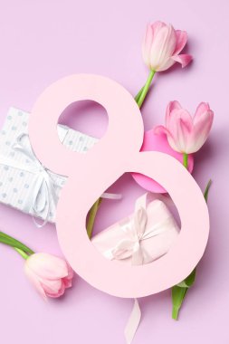 Kadınlar Günü kutlamaları için kağıt, hediye kutuları ve lale çiçeklerinden yapılmış 8 figürü pembe arka planda.