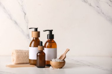 Mermer zemin üzerinde lif süngeri ve şişe kozmetik ürünleri içeren spa kompozisyonu, yakın plan.