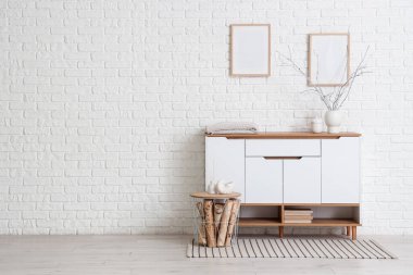 Beyaz tuvaletli, tablolu ve boş çerçeveli odanın içi