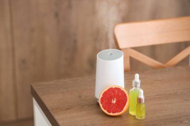 Mutfaktaki masada yağlı ve greyfurtlu hava nemlendirici, yakın plan.
